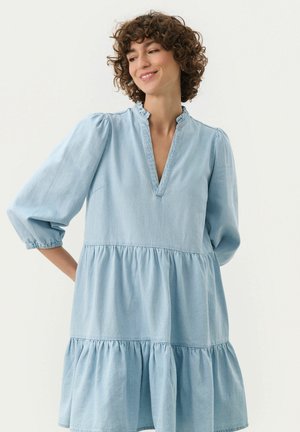 Helles blaues Denim-Kleid mit einem gestuften Design, Puffärmeln und einem Rüschenkragen. Verfügt über einen V-Ausschnitt und eine geraffte Taille.