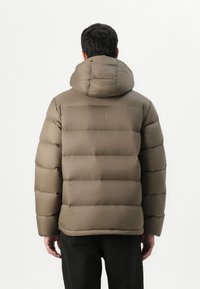 Brown puffer jacket with a hoodie, featuring a quilted design and a smooth texture. The jacket has a relaxed fit and visible stitching.
