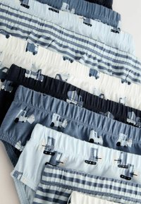 Huit paires de boxers pour garçons dans des teintes de bleu et de blanc, présentant des motifs de camions, des tailles élastiques et différents designs rayés.