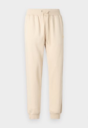 Beige joggingbukser lavet af blød bomuldsblanding. Har elastisk talje med snøre, tilspidsede ben og sidelommer.