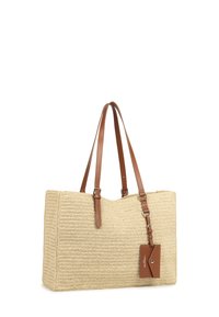 Borsa a spalla in paglia intrecciata con manici in pelle color cuoio e un'etichetta bagaglio coordinata. Forma rettangolare con superficie testurizzata e design aperto.