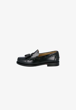 Mocasín de hombre en piel negra con borlas, costura moc toe y tacón bajo apilado, mostrado de perfil sobre fondo blanco.