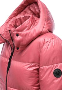 Różowa kurtka puchowa z ociepleniem, posiadająca wysoki kołnierz, fakturowany materiał, czarny zamek błyskawiczny oraz okrągłą naszywkę z logo na lewym rękawie.