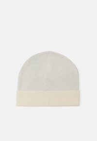 Cappello beanie in cotone grigio chiaro con bordo a coste crema. Il design è semplice e strutturato con una texture liscia e morbida.