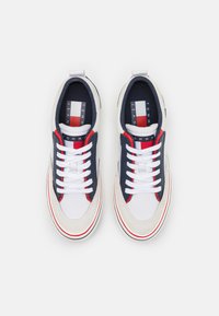 Sneakers con tomaia in pelle bianca, accenti blu navy, dettagli a strisce rosse e bianche e lacci bianchi. Interno in tessuto con logo.