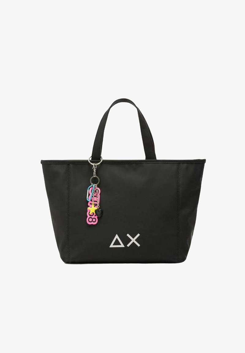 Borsa tote nera in nylon, con doppi manici, logo geometrico bianco e charm colorati attaccati a un portachiavi.
