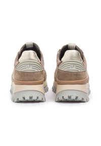 Baskets en daim marron clair avec des accents métalliques. Semelle épaisse, talon texturé et col rembourré. Présente un logo proéminent à l'arrière.