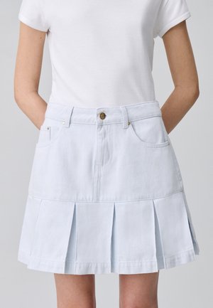 Gonna in denim azzurro chiaro con design plissettato, due tasche anteriori e chiusura a bottone frontale. Realizzata in tessuto leggero.