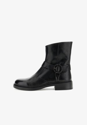 Bottines en cuir noir avec un bout rond, détails de sangle sur le côté et accent circulaire. Présente une texture lisse et un talon carré de 5 cm.