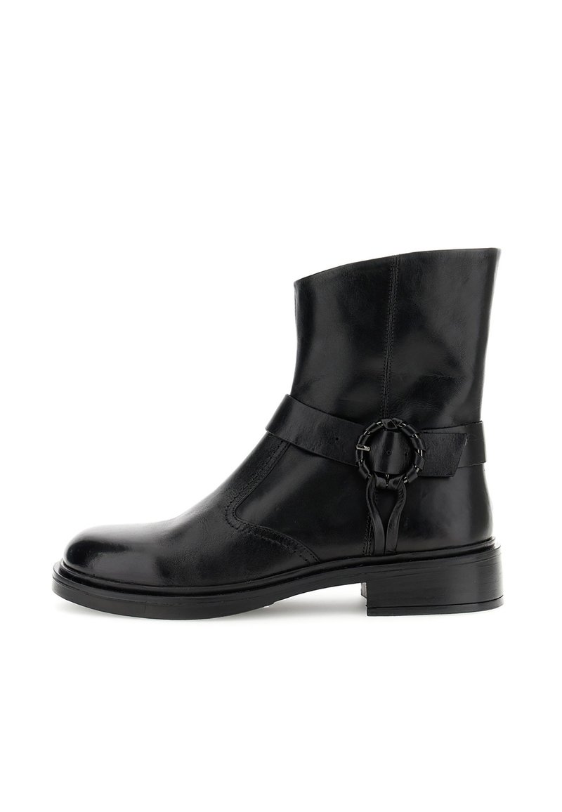 Bota de tobillo de cuero negro con punta redonda, detalle de correa lateral y un acento circular. Presenta una textura suave y un tacón de bloque de 2 pulgadas.