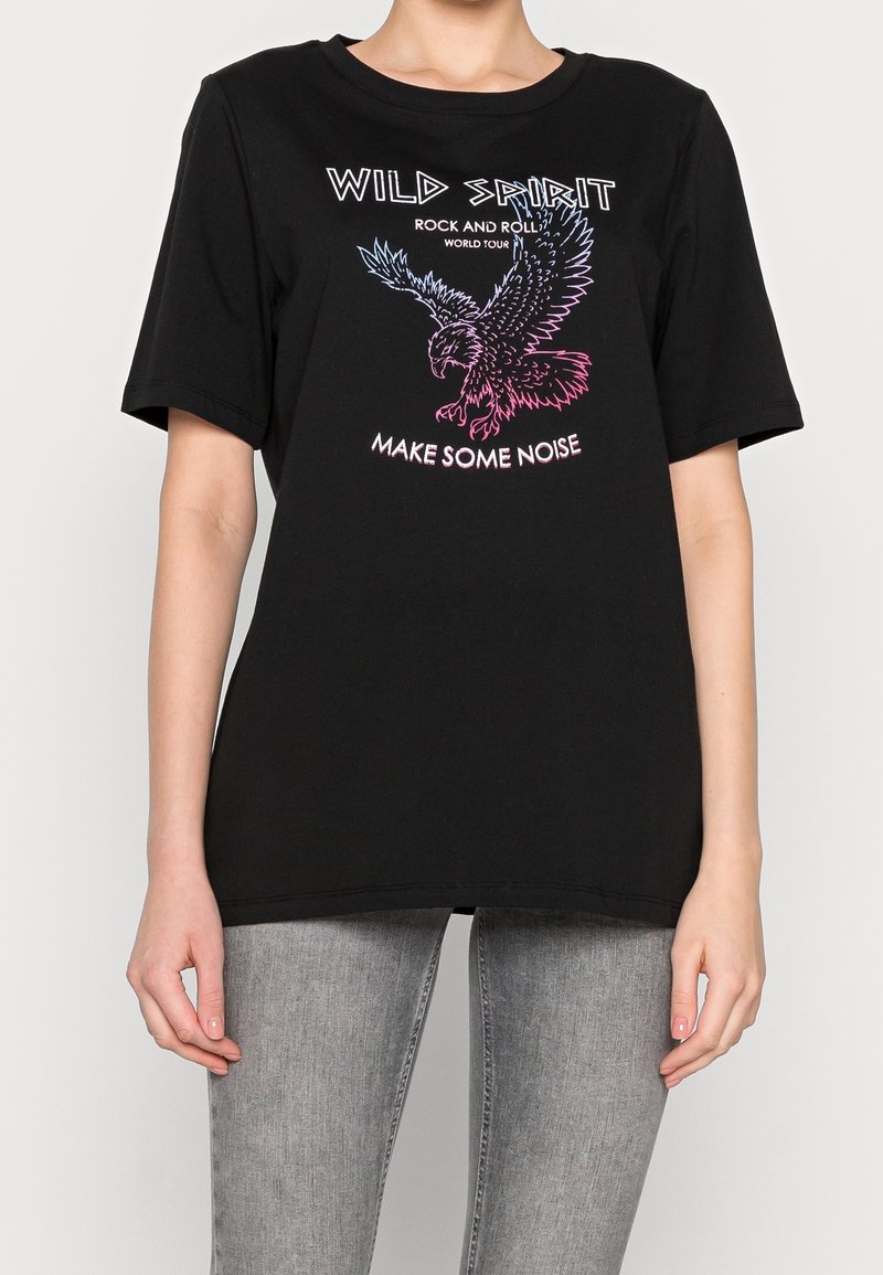Svart bomull t-shirt med en grafisk design av en örn i rosa och blått med texten "VILD SPIRIT ROCK OCH ROLL, GÖR NÅGON RUMMA".