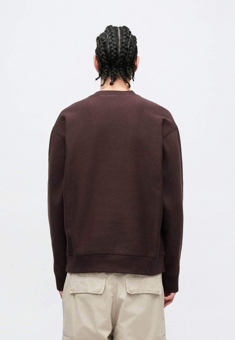 Brauner Sweatshirt mit rundem Halsausschnitt und gerippten Bündchen, mit lockerem Sitz und strukturierter Stoffstruktur, von hinten betrachtet ohne sichtbare Logos.