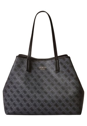 Sort Guess tote taske med mørkt monogrammønster, to lange håndtag og guld logo tekst foran.