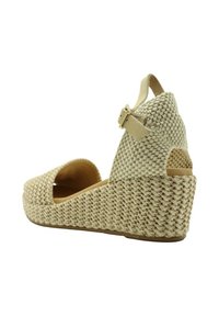 Sandalia de cuña tejida en color beige con diseño de punta abierta, correa de tobillo ajustable, parte superior texturizada y suela de plataforma resistente.