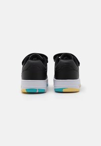 Black sneakers with a smooth leather upper, white midsole, and a multi-colored rubber outsole featuring aqua, pink, and yellow accents.