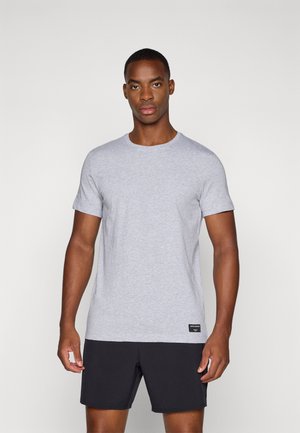 Grey short-sleeve t-shirt made of cotton blend fabric, featuring a round neckline and a small black label at the waist. Worn with black shorts.