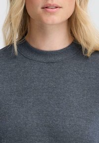 Grå genser med rund hals, med en glatt tekstur og ribbestrikket detaljering langs halslinjen. Enkel design, uten mønstre eller aksenter.