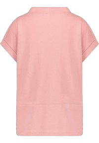 Top de algodón rosa de manga corta con un corte recto, mangas dobladas y un cuello. Textura suave con mínimos detalles de costura.