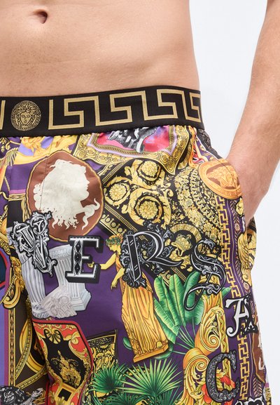 Πολύχρωμα μαγιό βερμούδα με μαύρη μέση που φέρει σχέδιο ελληνικού κλειδιού, διακοσμημένα με διάφορα γραφικά και περίπλοκα σχέδια.