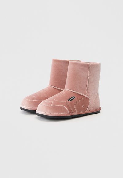 Stivaletti alla caviglia in velluto rosa con una texture liscia, punta arrotondata e cuciture intricate. Presentano un'etichetta nera sul lato e una suola in gomma.