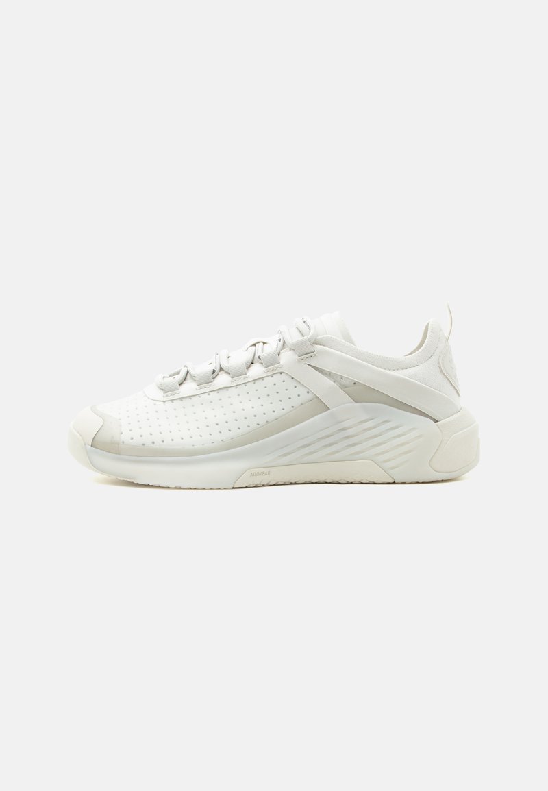 Λευκό sneaker με χαμηλό προφίλ, διάτρητο πλευρικό πάνελ, μαξιλαρωμένη σόλα, κλείσιμο με κορδόνια και ταινία για κράτημα στη φτέρνα, εμφανίζεται σε απλό φόντο.