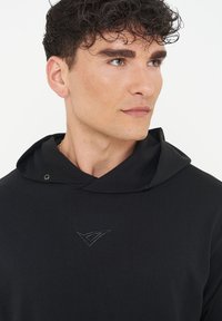 Black hooded sweatshirt with a soft texture, featuring a minimalistic design and a small logo accent on the chest.