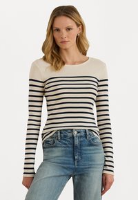 Kreemja ja laevaretse katkise pika varrukaga topp ümarate kaelustega. Pehme kangas, millel on horisontaalsed triibud ja lõdvestunud lõige. Kombineeritud teksadega.