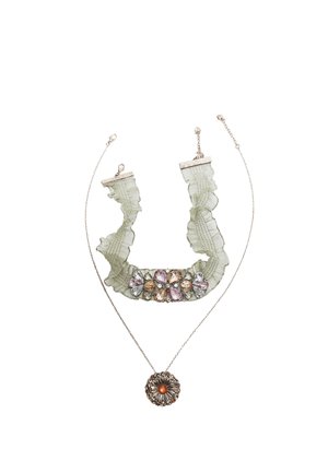 Deux colliers : une chaîne en or avec un pendentif floral rond au centre orange, et un ras du cou en tissu vert froncé avec un groupe de pierres précieuses multicolores.