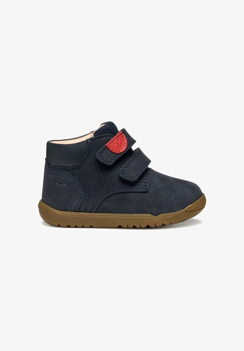 Dunkelmarineblaue Wildleder-Ankle Boots mit doppelten Velcro-Riemen, brauner Gummisohle und roten Akzenten an den Riemen. Mit glatten Lederdetails.