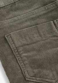 Tessuto in corduroy verde oliva con una texture a coste. Presenta una tasca posteriore cucita con un design a bordo dritto.