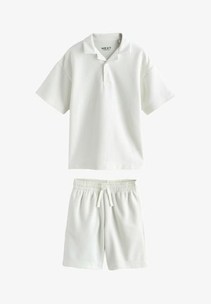 Weißes kurzärmeliges Poloshirt mit Knöpfen und Shorts mit elastischem Bund und Kordelzug, beide aus leichtem Stoff hergestellt.