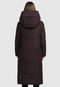 Brun isolerad lång kappa med huva, med chevron-sömmar och en logotyp längst ner till vänster. Slät textur och åtsittande ärmar.