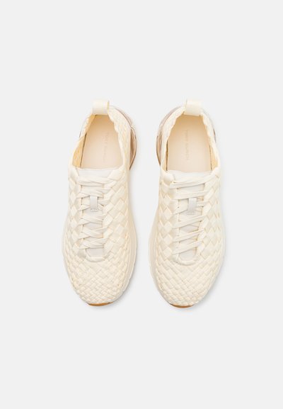 Sneakers bianchi in tessuto intrecciato con superficie testurizzata, lacci elasticizzati e dettagli suola trasparente. Punta arrotondata e linguetta per una facile calzata.