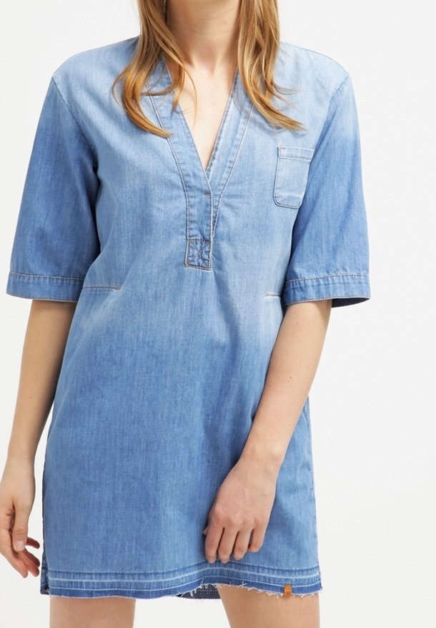 Denimmekko, jossa on V-pääntie ja lyhyet hihat, rintatasku, haalistunut sininen gradientti ja raaka helma alaosassa.