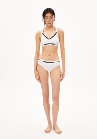 Witte bralette en bikini set met zwarte "ARMEDANGELS" branding op de banden, gladde stof en een minimalistisch ontwerp.