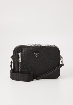Sac bandoulière en cuir texturé noir Guess avec fermetures éclair argentées, une bandoulière amovible et un logo triangulaire Guess à l'avant.