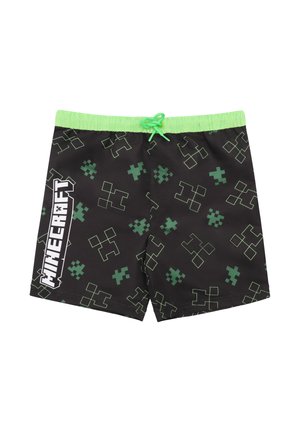 Schwarze Badeshorts mit grünem pixeliertem Muster und grünem Kordelzug. "Minecraft"-Logo in Weiß prominent an der Seite dargestellt.