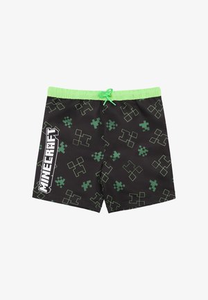Schwarze Badeshorts mit grünem pixeliertem Muster und grünem Kordelzug. "Minecraft"-Logo in Weiß prominent an der Seite dargestellt.