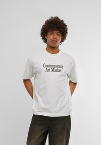 Hvit bomull T-skjorte med trykt tekstdesign "Contemporary Art Market" i svart. Korte ermer og klassisk rund hals.