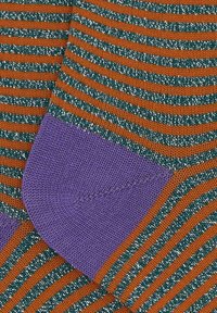 Calzini a righe con strisce arancioni e verdi con accenti argento, completati da tallone e punta viola. Tessuto morbido a maglia.