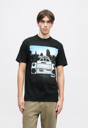 Camiseta de algodón negra con un gráfico de un boombox y el skyline. Manga corta, cuello redondo, corte relajado, con una textura suave.