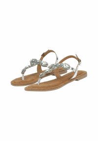 Sandali piatti con una soletta in suede color cuoio e cinturini metallici argento. Presentano gemme decorative lungo il dorso del piede. Chiusura con fibbia alla caviglia.