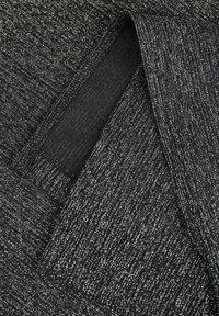 Sort og sølv textured stof med en metalisk glans, der har et subtilt linjært mønster og en glat inderside.