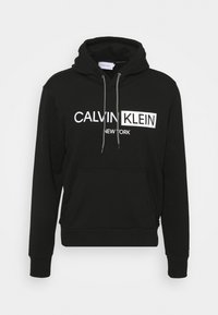 Felpa nera in cotone misto, con tasca frontale, cappuccio regolabile e logo bianco "CALVIN KLEIN NEW YORK" in stampa grassetto.