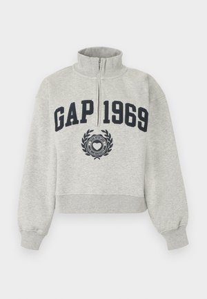 Jasnoszara bluza z półzamkiem, z napisem „GAP 1969” w granatowych literach oraz emblematem serca poniżej napisu na środku przodu.