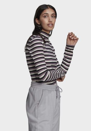 Paita pitkällä hihalla, jonka raidat ovat violetteja ja kermaisia, jossa on mock-neck, yhdistettynä vaaleanharmaisiin collegehousuihin, joissa on joustava vyötärö.