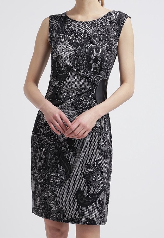 Robe cintrée sans manches avec un motif complexe en dentelle noire sur un tissu gris, dotée d'un col rond et de panneaux latéraux noirs.