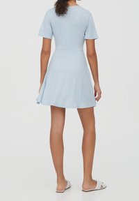 Vestido de manga corta azul claro con corsé ajustado y falda acampanada, que presenta un pequeño patrón floral en toda su superficie. Tejido suave, hasta la rodilla.
