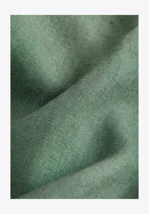 Tessuto di lino verde con una superficie tessuta e testurizzata. Il materiale ha una finitura morbida e naturale con sottili variazioni di colore.