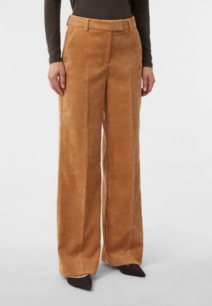 Szerokie spodnie ze sztruksu w bogatym, karmelowym kolorze, z teksturowanymi żeberkami, bocznymi kieszeniami i paskiem w talii. Odpowiednie na co dzień lub na formalne okazje.